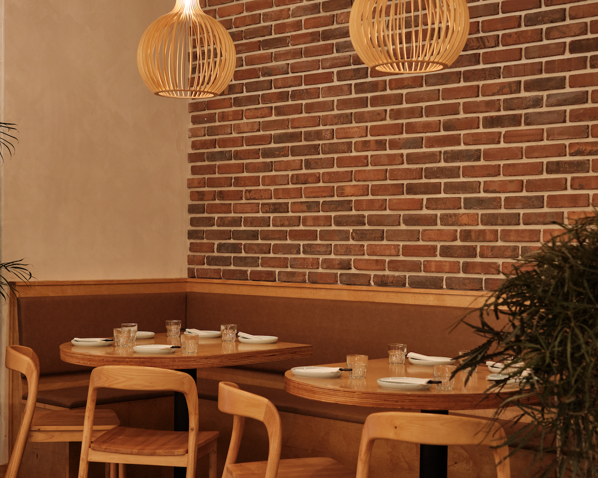 Wood-lined dining room and banquette seating at Breeze Greenpoint