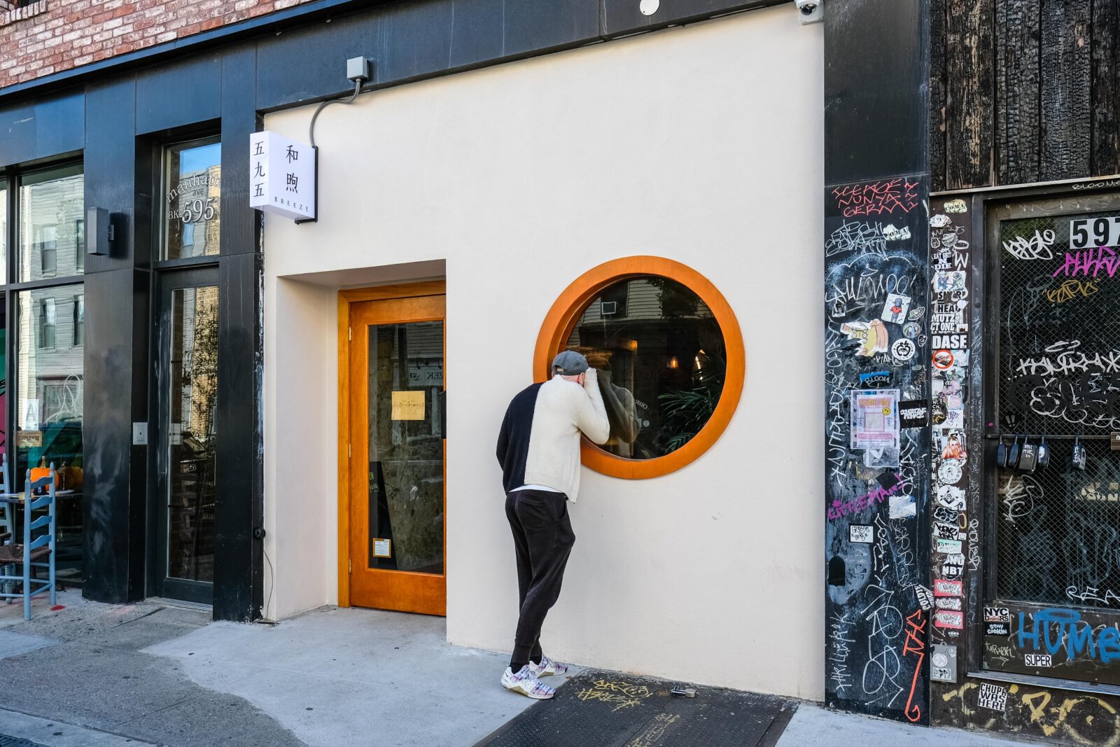 White storefront and circular orange window at Breeze Greenpoint